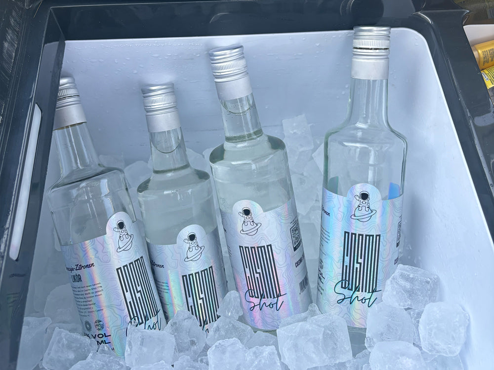 vier Flaschen Cosmo Shot in einer mit Eiswürfeln gefüllten Kühlbox